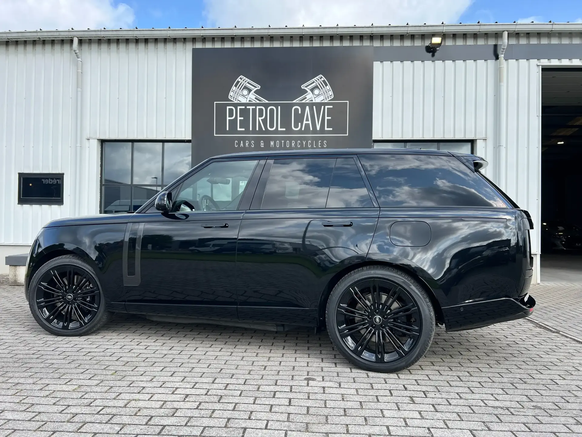 Black Range Rover in front of the Petrol Cave building